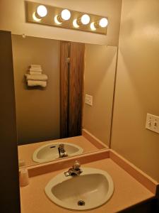 a bathroom with a sink and a mirror at Ranchland Villa Motel in Merritt