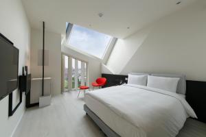 a bedroom with a large white bed and a window at The Place Taichung in Taichung