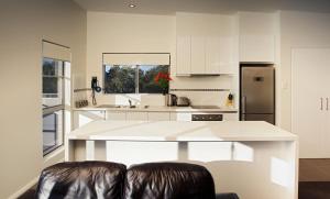 a kitchen with a refrigerator, stove, sink and dishwasher at Charlestown Terrace Apartments in Newcastle