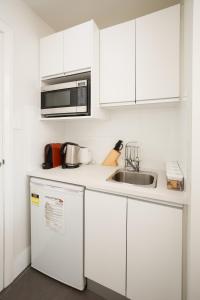 a kitchen with a stove, microwave, sink and refrigerator at Charlestown Terrace Apartments in Newcastle