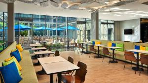 新加坡Holiday Inn Express Singapore Katong by IHG的一间带桌椅和蓝伞的餐厅