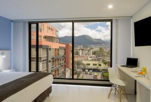 - une chambre avec un lit et une grande fenêtre dans l'établissement Hotel Regency Boutique La Feria, à Bogotá