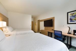 a hotel room with two beds and a desk and a tv at Holiday Inn Express San Jose Costa Rica Airport by IHG in Alajuela City
