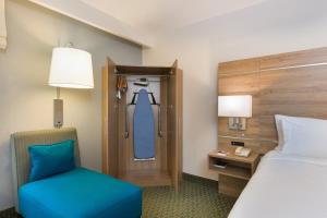a hotel room with a bed and a blue chair at Holiday Inn Express San Jose Costa Rica Airport by IHG in Alajuela City