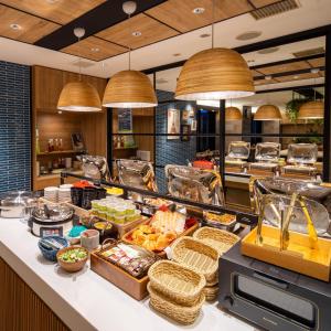 a buffet line with food on a counter with pendant lights at Super Hotel Nagaizumi Numazu Inter in Nagaizumi