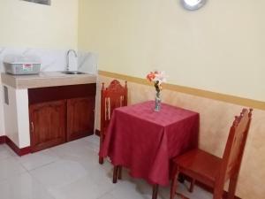 a kitchen with a table with a vase of flowers on it at Lucky Garden Inn in Puerto Princesa City