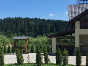 a building with a gazebo next to a forest at VIP House cottages in Mykulychyn