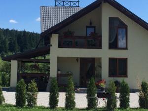 a house with a balcony on the front of it at VIP House cottages in Mykulychyn