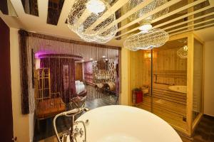 baño con bañera y lámparas de araña en EROS Hotel - Love Hotel, en Ho Chi Minh