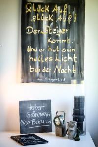een schoolbord met een klok op een tafel naast een klok bij art Hotel Körschen in Essen