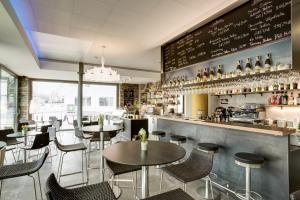 a restaurant with tables and chairs and a bar at Hotel SiX in Kreuzlingen