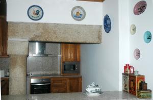 uma cozinha com um fogão e um micro-ondas em Casa Dos Lagares De Vara E Pedra em Vila Flor