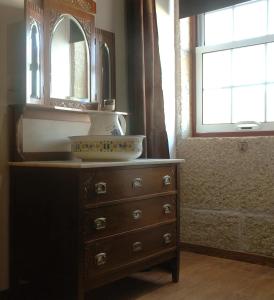 a bathroom with a dresser with a sink and a mirror at Casa Dos Lagares De Vara E Pedra in Vila Flor