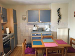 eine Küche mit einem Holztisch sowie einem Tisch und Stühlen in der Unterkunft Ferienwohnung Marienhof OG in Seelbach