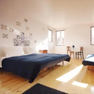 ein Schlafzimmer mit einem Bett mit einer blauen Decke darauf in der Unterkunft Lisbon Story Guesthouse in Lissabon