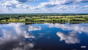 uma vista aérea de um lago com nuvens na água em DvīņuMājas em Balvi
