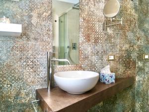 a bathroom with a white bowl sink on a counter at Colibrì House ApartSuite Chioggia in Sottomarina +40 photos