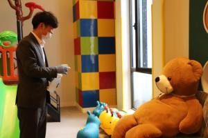 een man in een pak die naast een grote teddybeer staat bij Crowne Plaza Wuzhen, an IHG Hotel in Tongxiang