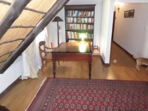 Foundry Guest Lodge في بريتوريا: غرفة معيشة مع طاولة وكلب يتجول