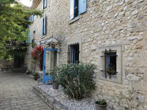 un bâtiment en pierre avec des plantes devant lui dans l'établissement Logis Le Mas de Valaurie, à Valaurie