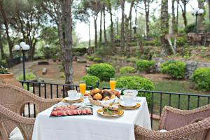 a table with a plate of food and a basket of fruit at Hotel Garbi in Calella de Palafrugell