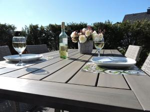 uma mesa de madeira com uma garrafa de vinho e dois copos em Appartement - Haus Winterberg em Winterberg