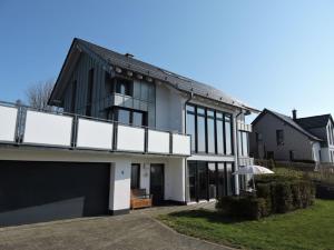 a black and white house with a balcony at Appartement - Haus Winterberg in Winterberg