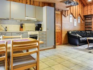 eine Küche und ein Wohnzimmer mit einem Tisch und einer Couch in der Unterkunft Holiday Home Kantapää d3 by Interhome in Luosto