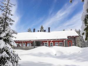 een huis bedekt met sneeuw en met sneeuw bedekte bomen bij Holiday Home Lustola a by Interhome in Luosto