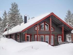 a log cabin with snow in front of it at Holiday Home Kerkänperä by Interhome in Luosto