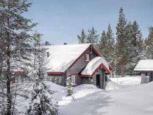 uma cabana de madeira na neve com árvores em Holiday Home Kerkänperä by Interhome em Luosto