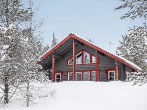 ルオストにあるHoliday Home Kerkänperä by Interhomeの雪が降る丸太のキャビン