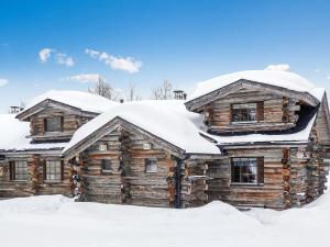 a log cabin with snow on top of it at Holiday Home Kantapää c 3 by Interhome in Luosto