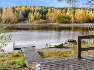 a green boat sitting on the shore of a lake at Holiday Home Pentintupa by Interhome in Muljakkala