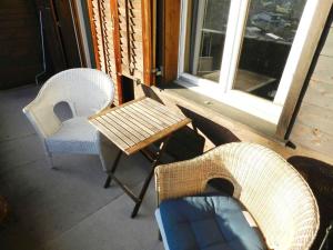 porche con 2 sillas, mesa y ventana en Apartment Hübeli - Chapman by Interhome en Zweisimmen