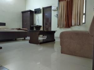 a living room with a couch and a table at Vamoose Jhamku Palace in Jhālāwār