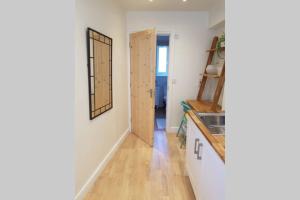 cocina con fregadero y espejo en la pared en Cosy, self contained annex en Cambridge