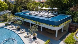 a swimming pool with chairs and a table and a pool at Melia Koh Samui in Choeng Mon Beach