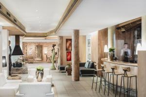 un vestíbulo con muebles blancos y un bar en Hotel Bad Schörgau en Sarntal