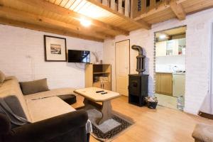 een woonkamer met een bank en een houtkachel bij Holiday Home Jazacka Bajka in Vrdnik