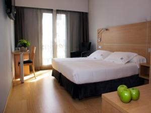 a hotel room with a large bed and a desk at Hotel Jauregui in Hondarribia