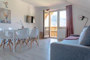 a living room with a table and white chairs at Apartmaji Triglav in Bohinj