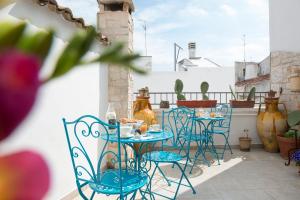 een tafel en stoelen op een patio met planten bij Manidibianco Apulian Relaxing Stay in Turi