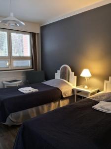 a hotel room with two beds and a window at Hotelli Ravintola Tiilikka in Rautavaara