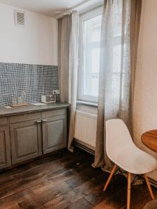uma cozinha com uma mesa, uma cadeira e uma janela em 2 Baloži em Kuldīga