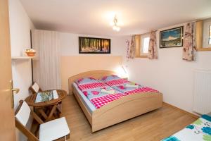 a small bedroom with a bed and a table at Apartment Stare in Bohinj