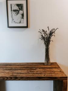 un vase de fleurs assis sur une table en bois dans l'établissement 2 Baloži, à Kuldīga