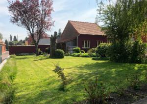 une maison avec une cour avec de l'herbe verte dans l'établissement Le cabinet de Benoni, à Nielles-lès-Bléquin