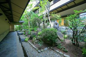 un jardin avec des rochers et des arbres dans un bâtiment dans l'établissement Hayamakan, à Kaminoyama