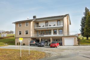 ein Gebäude mit Autos auf einem Parkplatz in der Unterkunft Stan's Bed & Breakfast in Untergriesbach